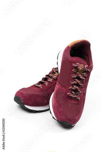 a pair of new burgundy, cherry sneakers or athletic shoes isolated on a white background.