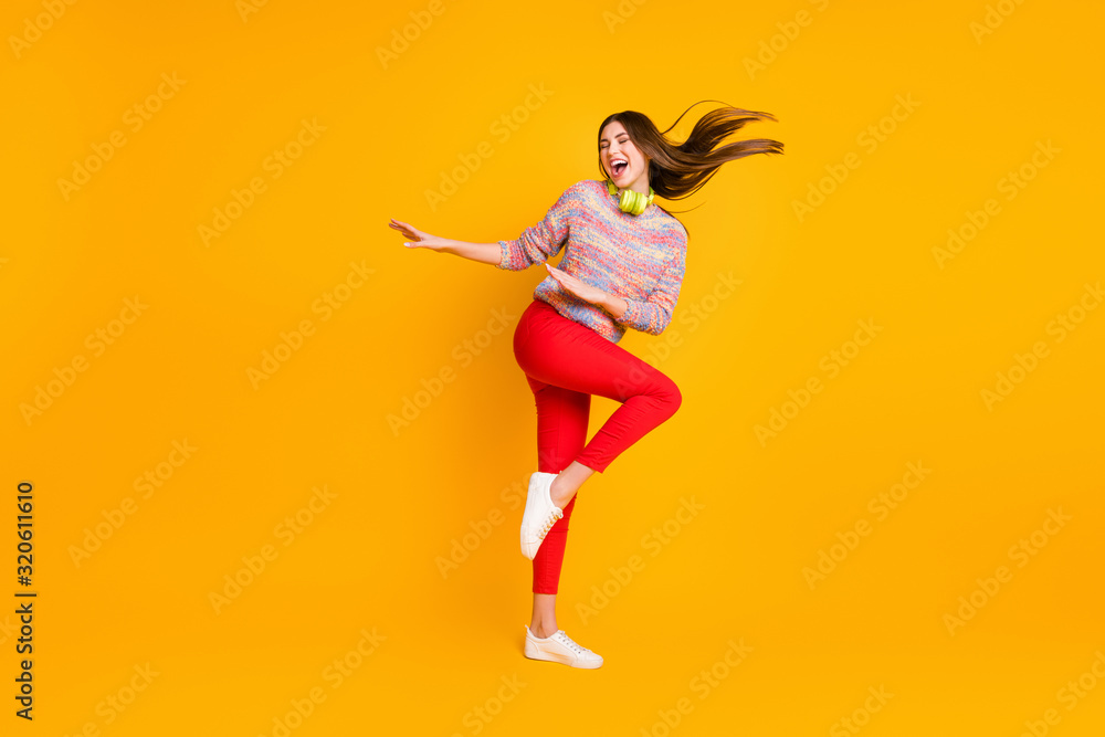 Full length photo positive cheerful dj girl listen melody music playlist headset dance dancer on disco floor party wear red pants trousers sweater gumshoes isolated yellow color background