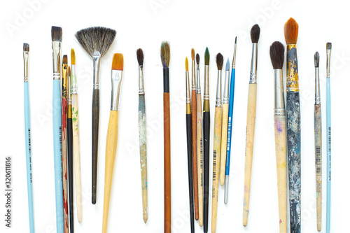 Used artistic paintbrushes isolated on white background. Close up shot of artist's equipment photo