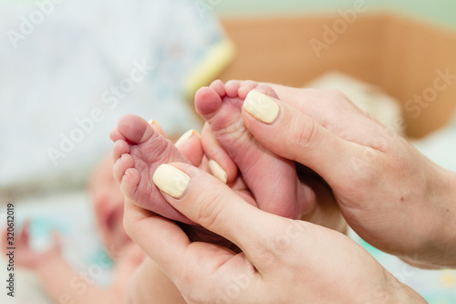 Newborn baby s feet in parents  hands