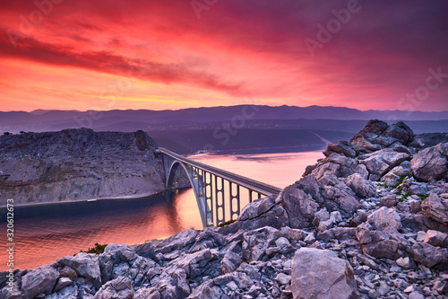 Dramatic summer seascape of Adriatic sea. Bigger arch Bridge to Krk Island at sunrise, near Maslenica, Croatia, Europe.  Bridge connects the Croatian island of Krk with the mainland. Morning light. photo