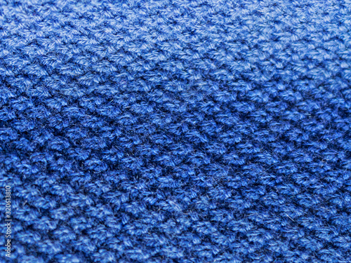 Texture of expensive natural knitted blue fabric with a rhombus pattern and a beautiful weave