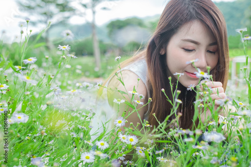 Asian women smelling white flowers in garden nature