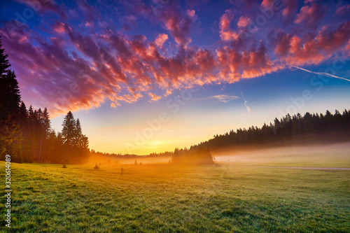 Amaizing sunrise view on Durmitor mountains, National Park, Mediterranean, village Zabljak, Montenegro, Balkans, Europe. Strange misty pasture in the sunlight. Bright summer view on alpine valley.