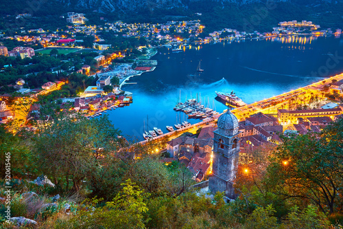Fantastic aerial panoramic summer view from the mountain to the bay of Kotor, Mediterranean Balkans, Montenegro, Europe. Traveling concept background. Incredible street lights in the sunset. Postcard.