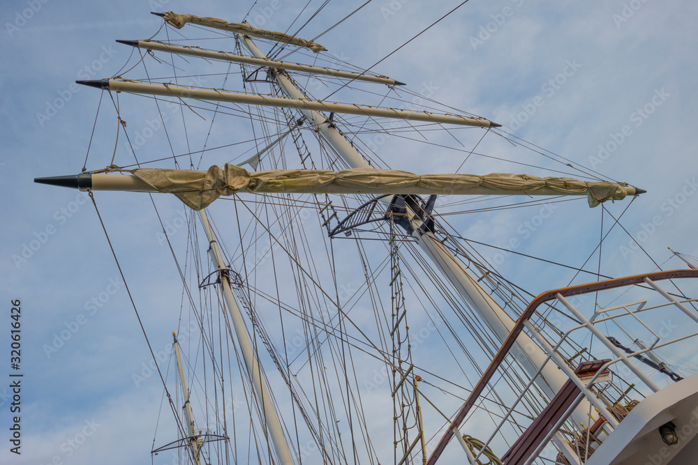 Rigging of a tall ship below a blue cloudy sky in sunlight in winter Rigging of a tall ship below a blue cloudy sky in sunlight in winter