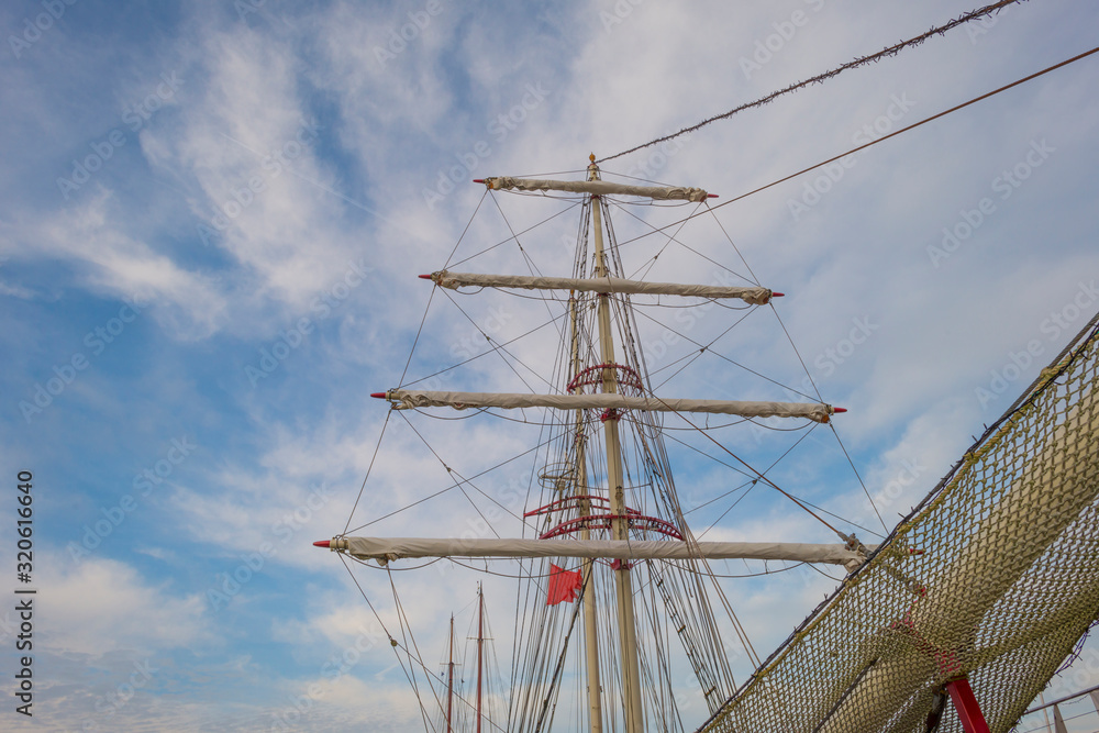 Rigging of a tall ship below a blue cloudy sky in sunlight in winter Rigging of a tall ship below a blue cloudy sky in sunlight in winter