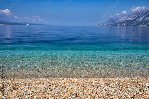 Fototapeta Naklejka Na Ścianę i Meble -  Amazing seascape of Adriatic sea. Colorful summer view of small Brela beach Croatia, Europe. Croatian coast with clear water and pine trees around. Tropical viewpoint for design postcard.