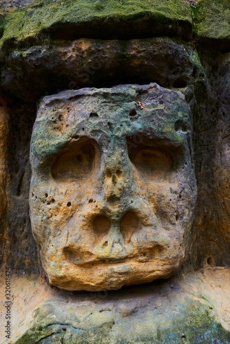 Rock sculptures of giant heads and other artworks Harfenice (Harfenist) carved into the sandstone cliffs in pine forest above village Zelizy by Vaclav Levy, Central Bohemia, Kokorin, Czech republic