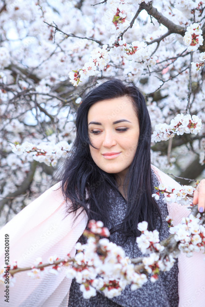  Brunette girl in a flowering cherry tree in spring