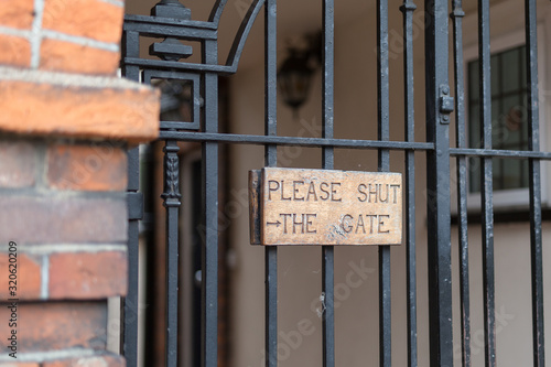 Wooden Sign on a Metal Gate: Please Shut the Gate