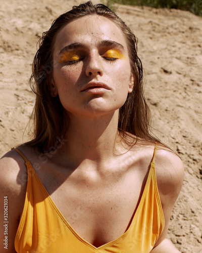  Girl in body, sneakers and socks on the beach