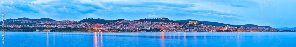 Large panorama of Unesco heritage historic town of Sibenik on Adriatic sea, Dalmatia, Croatia. Shot from the sea, harbor, waterfront and cathedral in front and ancient fort overlooking the town on.