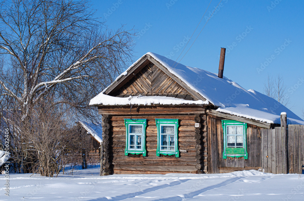 Winter landscape on a Sunny day. View of the Russian village in the snow. Authentic Wooden houses with carved frames. Winter landscape on a Sunny day. View of the Russian village in the snow. Authentic Wooden houses with carved frames.
