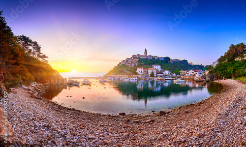 Fototapeta Naklejka Na Ścianę i Meble -  Town of Vrbnik (Verbnik) harbor view morning glow, Island of Krk, Kvarner bay archipelago, Croatia, Europe. Dramatic summer seascape of Adriatic sea. Stone beach. Incredible morning cityscape.