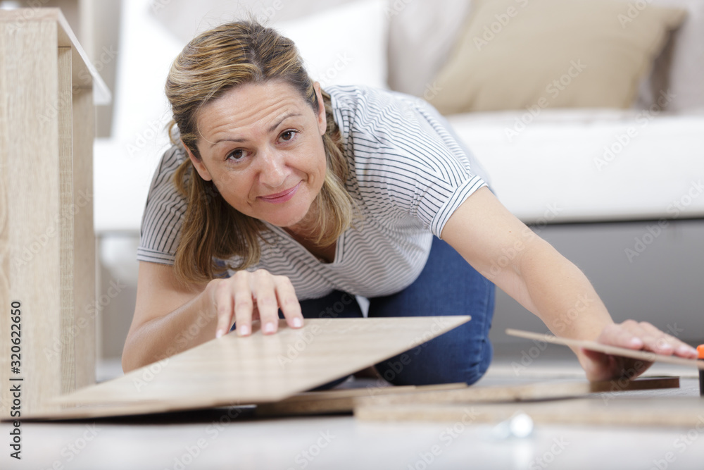 happy smiling woman assembling wood furniture happy smiling woman assembling wood furniture