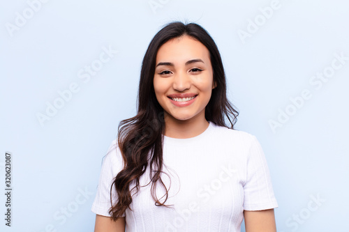 young latin pretty woman  against flat wall photo