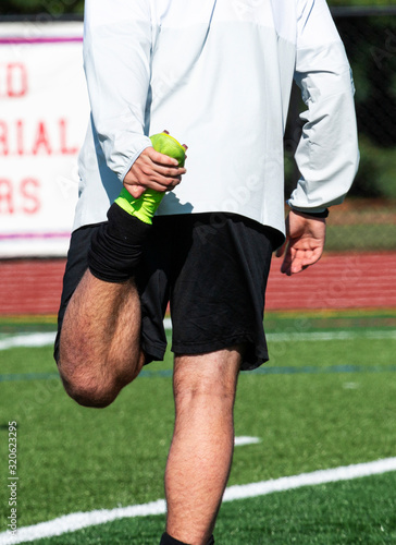 Soccer plsyer stretching before game photo