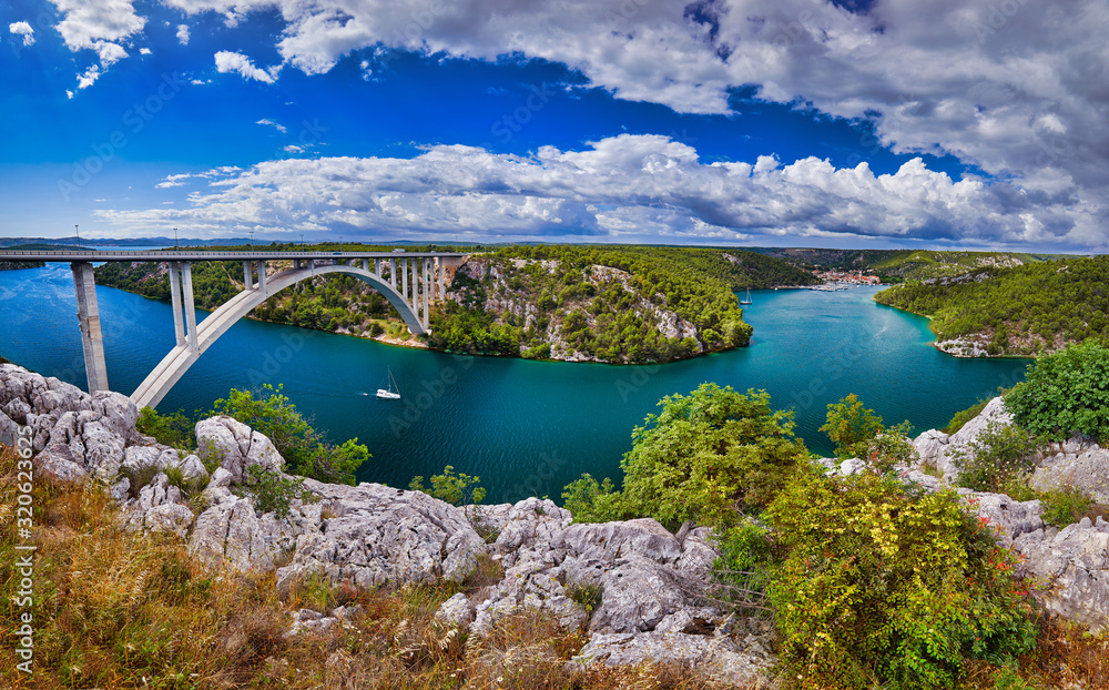 Sunlight view on the Sibenik Bridge a long concrete arch bridge passing through the canyon of the Krka River. Location Skradin town, Croatia, Europe. Travel destination. Discover the beauty of earth.