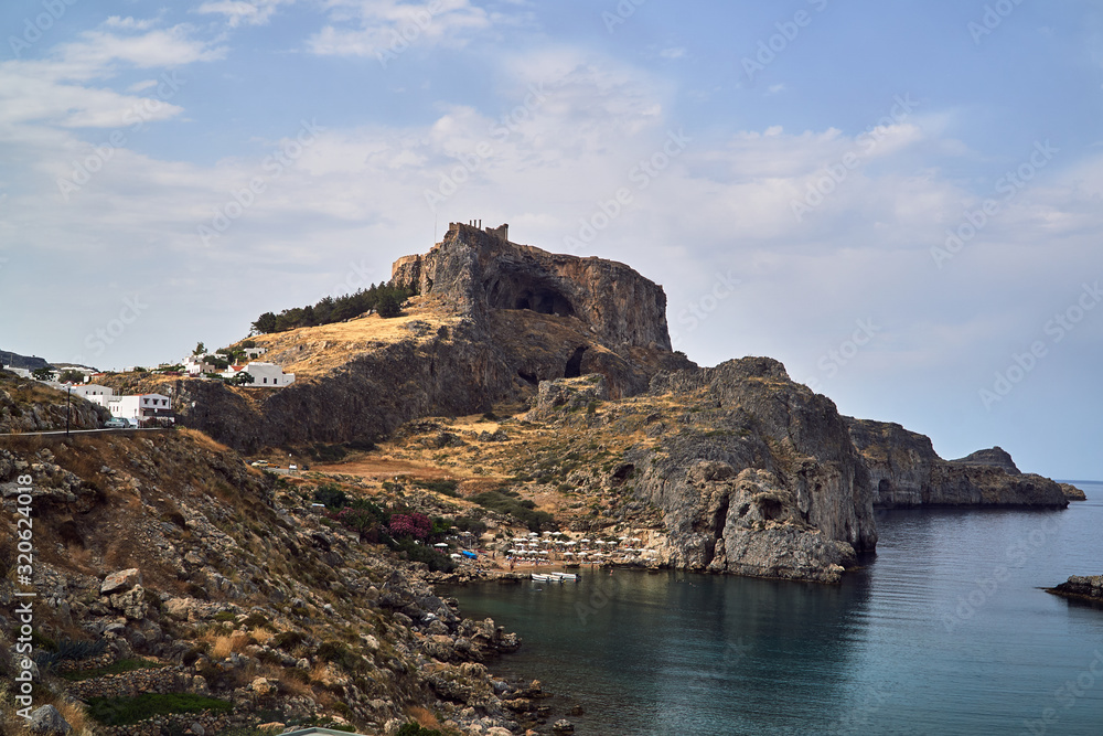 Rocky bay coast with the beach in the city of Lindos.