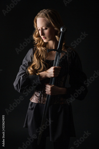 Girl in medieval dress with sword. Warrior girl. Medieval Female Warrior.