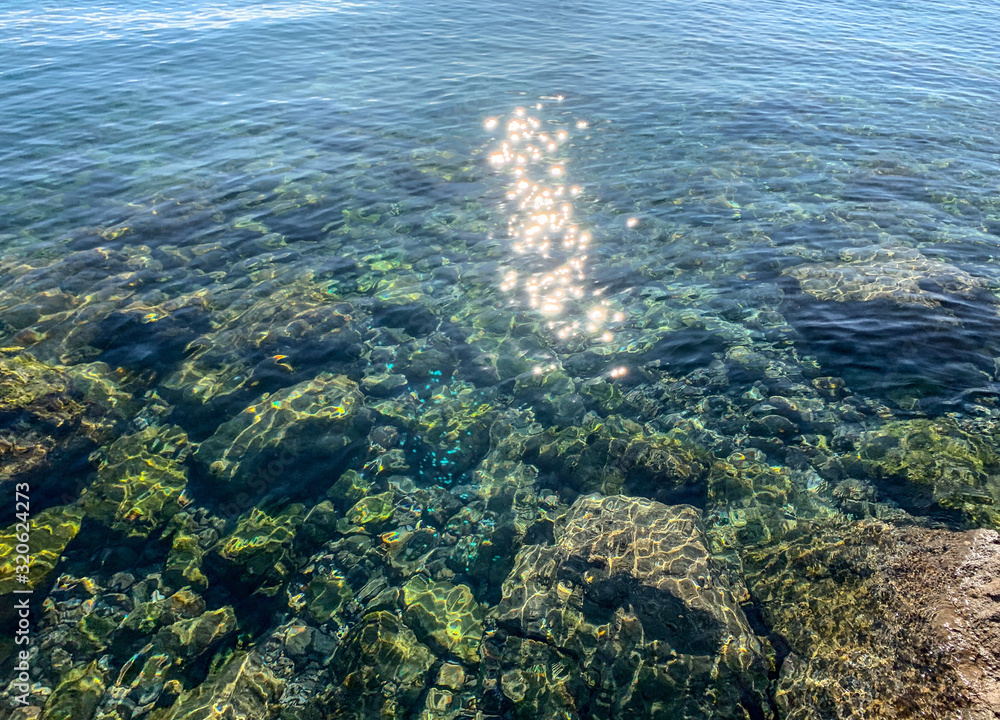 Fototapeta premium Sun glare on the sea surface, natural colors of the sea water, background