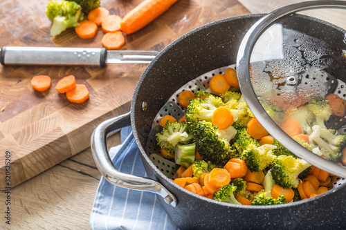 Foto Steamed mixed vegetable in black pot. Healthy vegetable concept