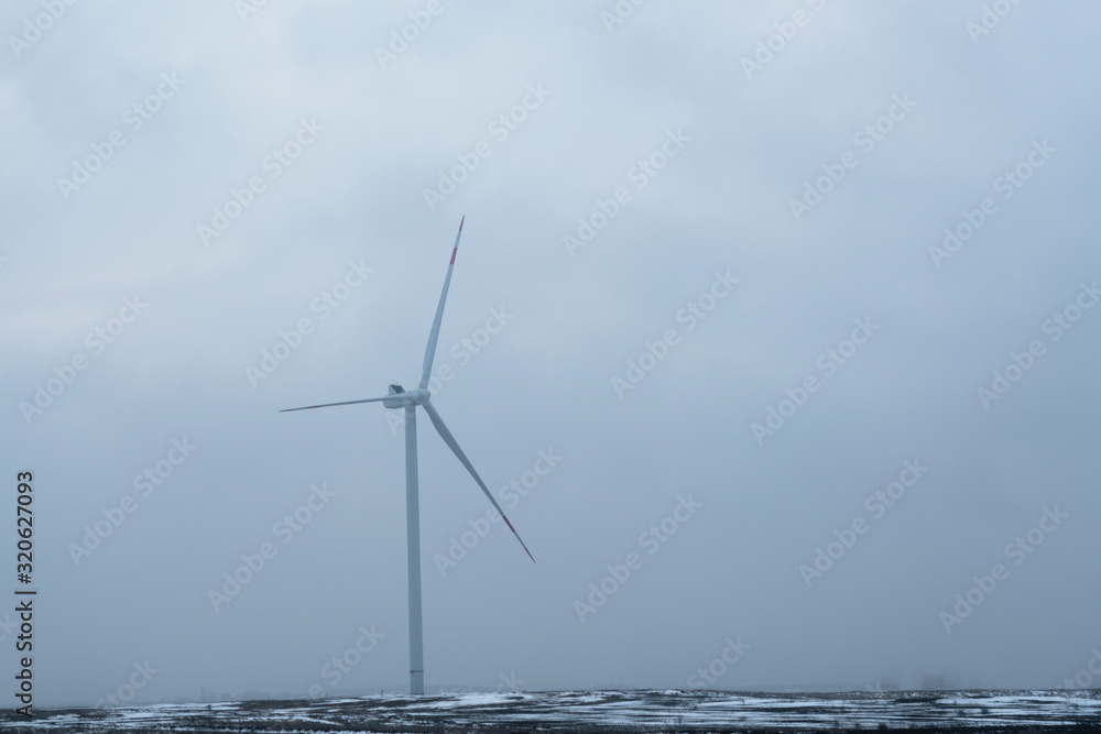  windmills in a foggy field.  alternative energy.