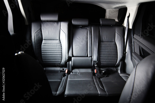Dark luxury new car Interior. Back passenger seats in modern car. Leather backseats and seatbelts