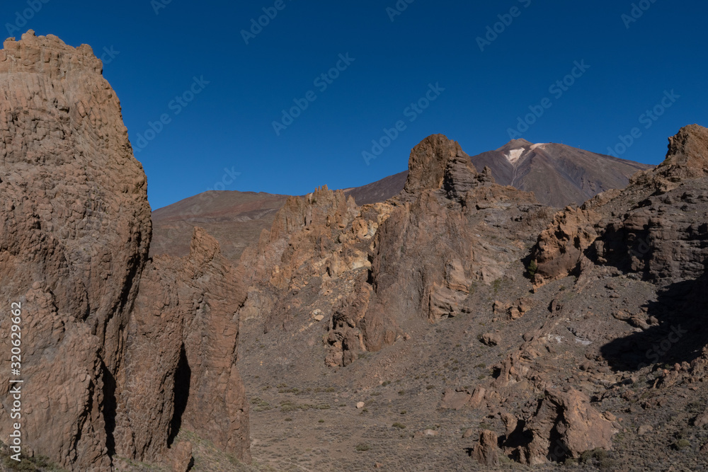 View of Roques de García unique rock formation with famous Pico del Teide mountain volcano summit in the background on a sunrise, Teide National Park, Tenerife, Canary Islands, Spain View of Roques de García unique rock formation with famous Pico del Teide mountain volcano summit in the background on a sunrise, Teide National Park, Tenerife, Canary Islands, Spain