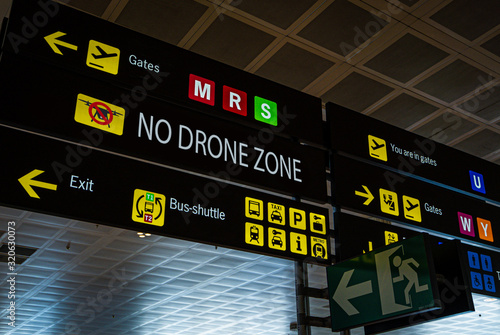 Information panel with No drone flying warning sign on it at an international airport. Drones are banned from airport aerial space, in addition to the physical collision risks that drones pose to an photo