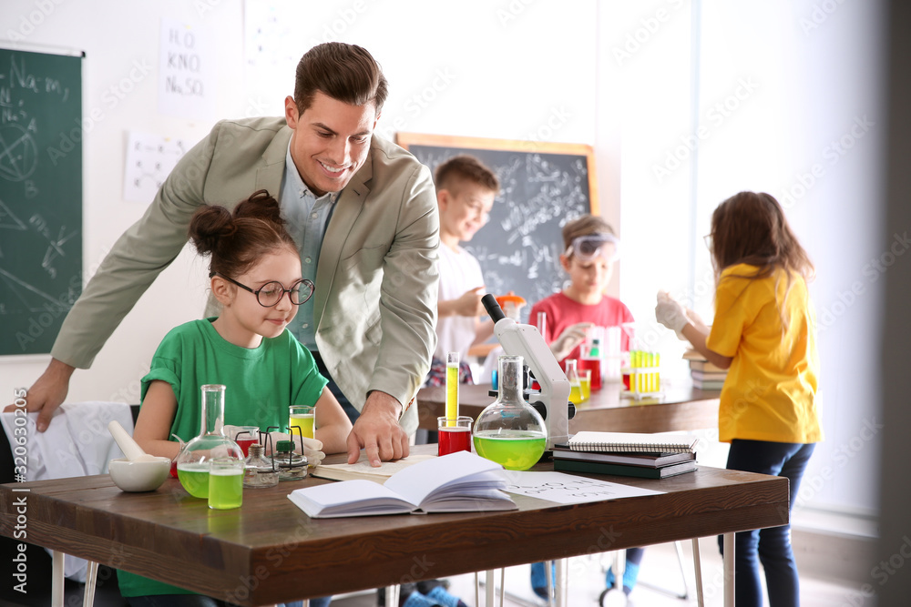 Teacher with pupils at chemistry lesson in classroom Teacher with pupils at chemistry lesson in classroom