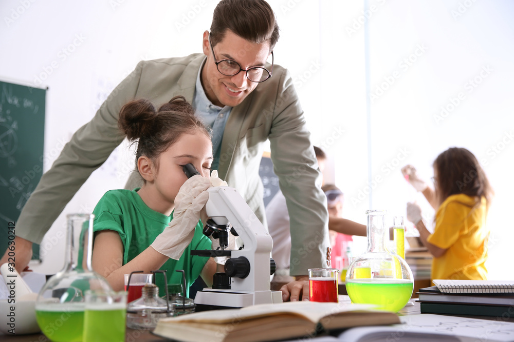 Teacher with pupil at chemistry lesson in classroom Teacher with pupil at chemistry lesson in classroom