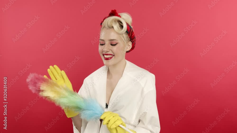 Smiling pin up woman in rubber gloves holding duster Smiling pin up woman in rubber gloves holding duster
