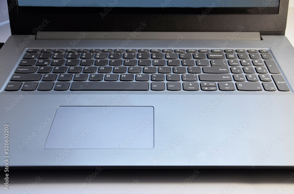 The silver laptop is open for work. Keyboard on the computer. The silver laptop is open for work. Keyboard on the computer.