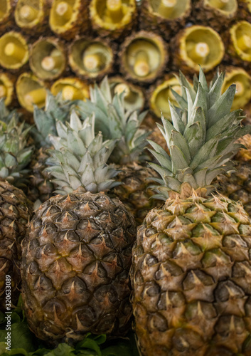 Close up of pineapples  and sliced fresh pineapples  at a local market. Healthy vegetarian food.