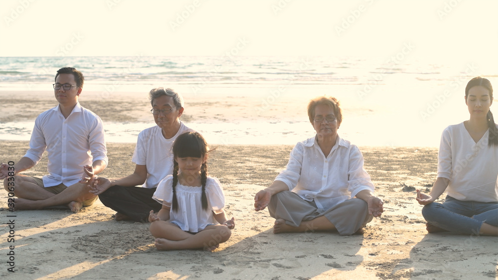 Holiday concept. A large family practicing yoga together by the sea. 4k Resolution.