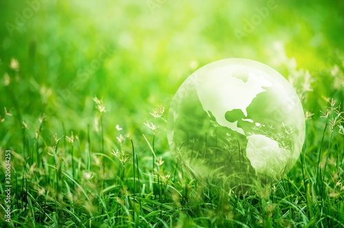 Earth glass on green grass in sunlight, Save the World for the Next Generation concept, Earth day concept
