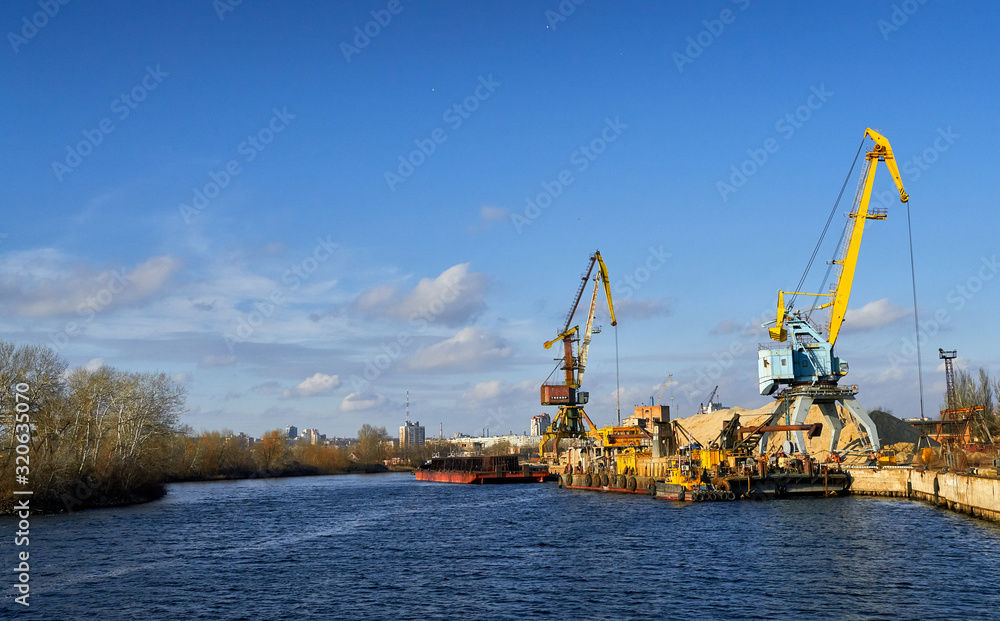 two cranes stand on a pier in the port