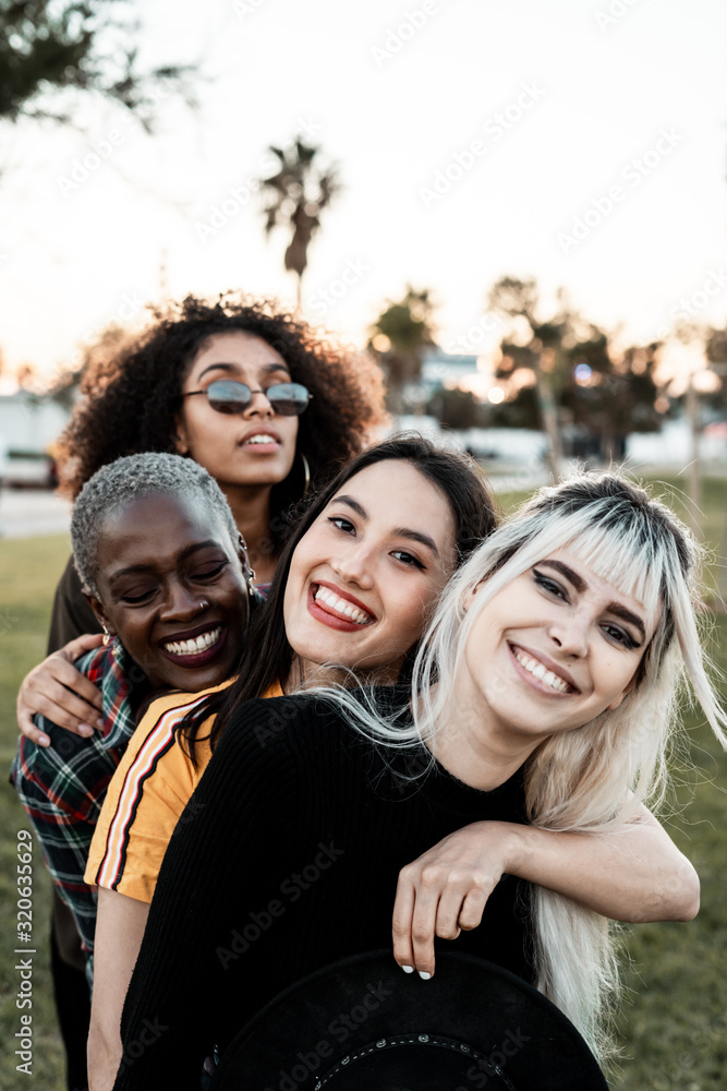 Multiethnic group of female hipsters cuddling with each one Multiethnic group of female hipsters cuddling with each one