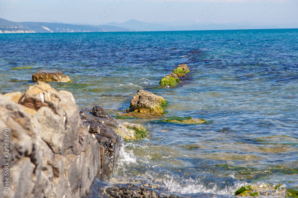 Rocks with a black hue on the black sea coast on a clear Sunny day