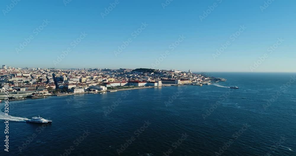 Aerial revealing view of the skyline of the city of Lisbon with the Comercio Square, the Alfama Neighbourhood and the Tagus River, in Portugal Aerial revealing view of the skyline of the city of Lisbon with the Comercio Square, the Alfama Neighbourhood and the Tagus River, in Portugal
