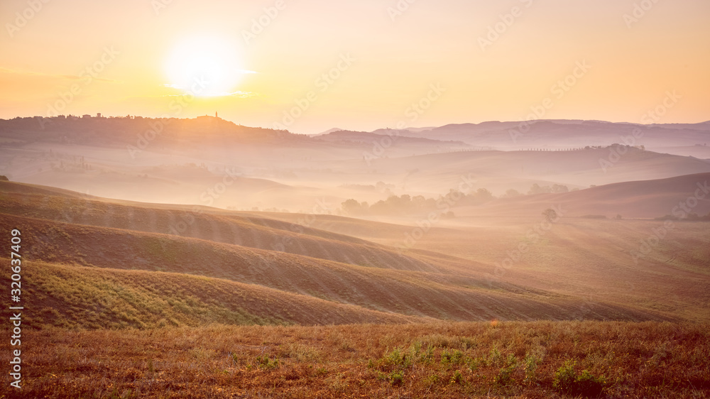 Beautiful wide angle view of Tuscany hills at pink hour sunrise. Travel destination Tuscany, Italy