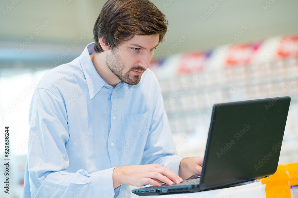 young man using laptop in workplace young man using laptop in workplace