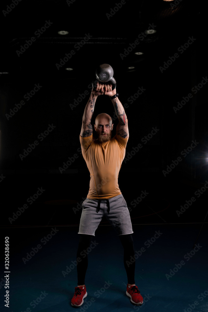 sporty bald man with tattooed arms