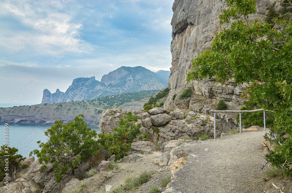 A tourist route along a trail in the mountains of the southern coast of Crimea, a beautiful view of the Black Sea and rocks. Golitsyna trail, Republic of Crimea