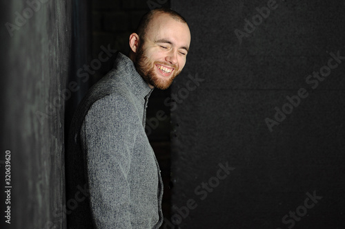 Portrait of happy handsome man in gray suit against gray background. photo