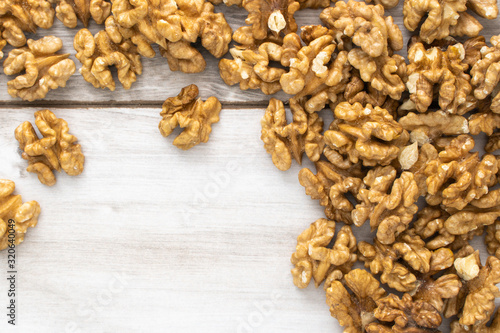 Scattered walnuts on wooden table, stock photo.