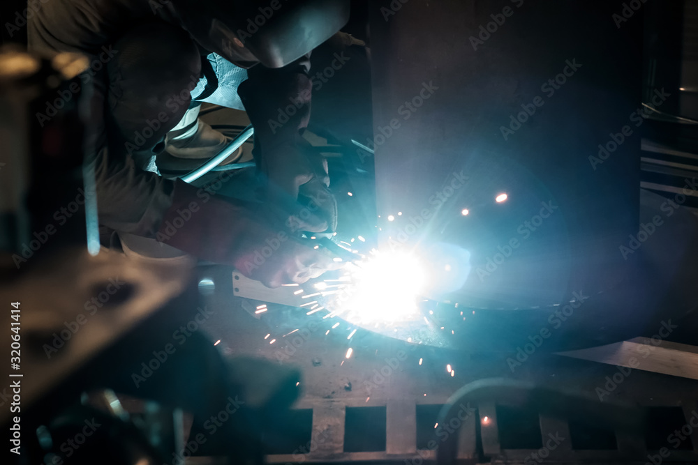 Man in protective gloves cutting metal using angle grinder making sparks Man in protective gloves cutting metal using angle grinder making sparks