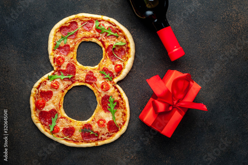 8 pizza  a bottle of wine and Gift for International Women s Day March 8 on a stone background with copy space for your text. March 8 celebration concept.
